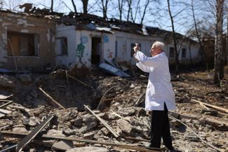 Dr. Anatoly Pavlov takes photos of bombed psychiatric hospital in Mykolayiv.