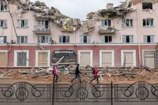 Жители Чернигова у разрушенной гостиницы «Украина». Мэр города заявил, что город уничтожен на 70%