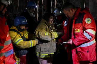 Спасатели и врачи помогают 27-летней беременной Анне эвакуироваться из дома, куда попала российская ракета