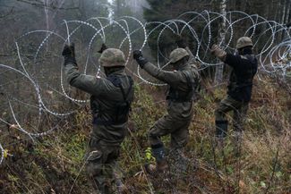 Польские солдаты устанавливают колючую проволоку вдоль границы Польши с Россией (Калининградская область). 7 ноября 2022 года 