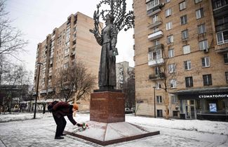 Житель Москвы возлагает цветы к монументу Лесе Украинке в память о погибших в городе Днепре. 23 января 2023 года