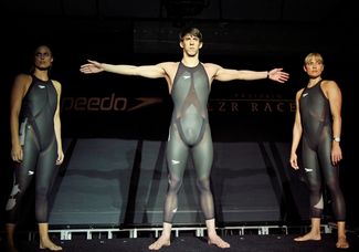 Американские пловцы Аманда Бирд, Майкл Фелпс и Натали Коглин представляют костюмы Speedo для Олимпийский игр в Пекине, 2008 год