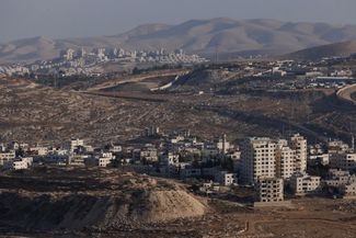 Палестинский город (внизу) и израильское поселение (вверху) на Западном берегу