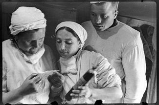 Врачи Столярова и Назарова и ефрейтор Шака читают на ампуле с кровью письмо донора Шемякиной, село Шули, апрель 1944 года