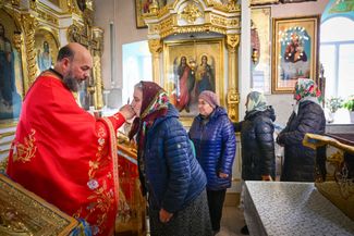 Orthodox priest Ioan Solonaru blesses believers during a religious service at his church in the village of Cimișeni. November 12, 2023.