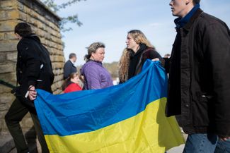 Жители Нарвы с украинским флагом на набережной