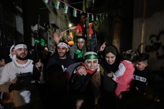 Бывшая палестинская заключенная Асиль аль-Тити со своими друзьями и родными в Наблусе на Западном берегу Иордана, 24 ноября 2023 года. На голове у девушки зеленая повязка террористического движения ХАМАС.