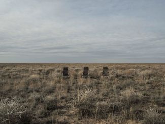 Three chairs sit in the Kazakh steppe near a spacecraft landing zone. For many years, cosmonauts and astronauts have sat in chairs like these after emerging from Soyuz landing crafts. Kazakhstan, October 2016.