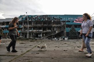 Жительницы Измаила на фоне портового терминала, поврежденного российскими дронами