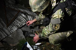 Украинский следователь осматривает обломки, оставшиеся после российского обстрела