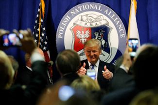 <br>Кандидат в президенты от Республиканской партии Дональд Трамп одобрительно поднимает вверх большой палец, в то время как ему поют песню по-польски и желают удачи после выступления перед Польским национальным союзом в Чикаго. 28 сентября 2016 года
