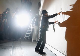 Йоко Оно вырезает часть холста в рамках своей работы «Вырезание холста» в галерее «Ханч оф Венисон». Берлин, Германия, 10 сентября 2010 года