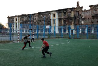 Подростки играют в футбол у разрушенного здания школы № 134 на севере Харькова. В феврале в школе укрылся российский спецназ, который пытался зайти в город. ВСУ взяли здание штурмом