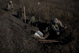 Украинские саперы раскапывают ракету системы залпового огня