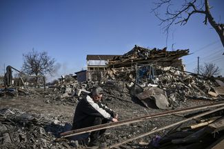 Мужчина у разрушенного обстрелами дома в селе Красиловка на востоке от Киева