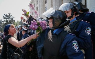 Женщина бьет полицейских букетом на следующий день после пожара в Доме профсоюзов, 3 мая 2014 года
