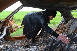 Ольга Хоменко из села Малая Рогань под Харьковом ищет останки своего сына в машине, в которую попал снаряд от российского танка