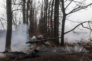 Военный украинской армии стреляет из самоходной артиллерийской установки (САУ)