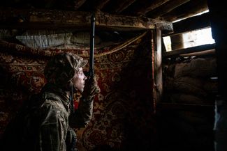 Украинский военнослужащий смотрит в перископ — оптический прибор для наблюдения из укрытия