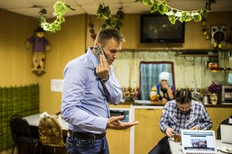Летом 2015 года Навальный попытался собрать новую оппозиционную коалицию вместе с «Парнасом» Михаила Касьянова и «Открытой Россией» Михаила Ходорковского. Ее первой целью были парламентские выборы в нескольких регионах России — но в итоге оппозиционный список пропустили в бюллетень только в Костромской области и лишь за несколько недель до выборов. Навальный провел в регионе несколько митингов, но оппозиция провалилась, набрав чуть больше 2% голосов. На фотографии, сделанной 4 сентября 2015 года, Алексей Навальный и его соратник Леонид Волков занимаются штабными делами в придорожной блинной