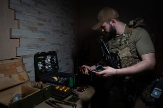 Офицер 59-й мотопехотной дивизии ВСУ готовит боеприпасы для сброса с дронов на российскую технику и позиции под Донецком. Ударные дроны стали одним из основных средств поражения противника на этой войне
