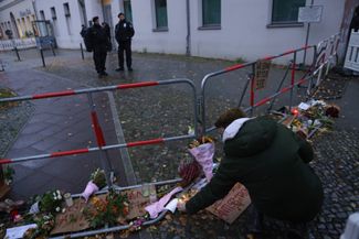 Цветы и свечи рядом с синагогой в Берлине, которую закидали «коктейлями Молотова». 20 октября 2023 года