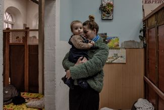 Украинка Лилия Мартынова и ее восьмимесячный сын в центральной синагоге «Агудат Исраэль» в Кишиневе. Они ждут автобуса, который отвезет их в аэропорт города Яссы в Румынии, на границе с Молдовой. Оттуда они вылетят в Израиль. 7 марта 2022 года