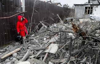 Женщина возле уничтоженного ракетным ударом жилого дома на окраине Киева