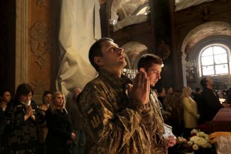 Солдаты на воскресной службе в Гарнизонном храме Святых Петра и Павла во Львове. Многие иконы закрыты для защиты от бомбардировок.