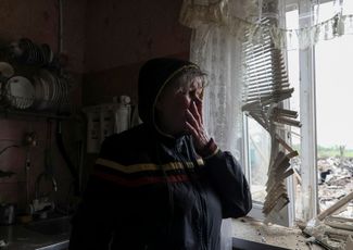 61-летняя жительница Павлограда Ольга Литвиненко смотрит на последствия обстрела из окна своего дома