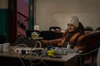Жительница Часова Яра заряжает телефон в пункте, организованном из-за постоянных перебоев с электричеством