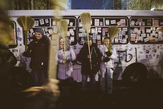 Протестующие проводят перформанс около одного из автобусов, которые милиция использует для блокирования проходов в правительственный квартал. 8 декабря 2013 года.