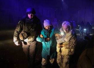 Полицейский помогает жительницам Харькова после обстрела