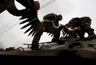 Военнослужащие пророссийских войск загружают боеприпасы в бронетранспортер во время боев в Мариуполе