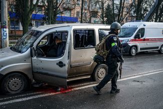 Украинский полицейский у автомобиля, водитель которого погиб в результате ракетного обстрела