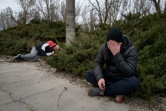 Мужчина сидит рядом с телом убитого друга. Он погиб во время российского артиллерийского обстрела Херсона