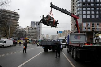 Фрагмент упавшей в Киеве ракеты грузят в машину