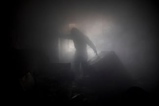 Фотограф AFP Димитар Дилкофф запечатлел последствия попадания артиллерийских снарядов в жилой дом в Бахмуте, в частности, в квартиру 63-летней местной жительницы Людмилы Харченко. На фото — пожарный борется с последствиями возгорания в помещении