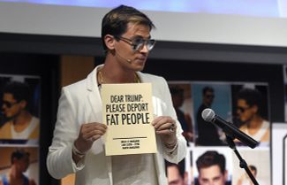Майло Яннопулос держит табличку с надписью «Дорогой Трамп: пожалуйста, депортируй толстых» во время выступления в университете Колорадо, 25 января 2017 года