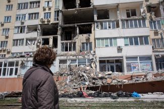 Жительница дома, чья квартира была разрушена в результате ракетного удара, наблюдает за работой спасателей. Одесса была обстреляна 23 апреля, жертвами атаки, по предварительным данным, стали восемь человек, в том числе трехмесячный ребенок