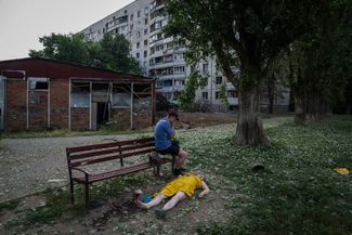 Житель Харькова у тела женщины, погибшей в результате обстрела города