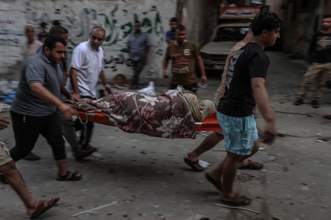 Жители Газы несут раненого в лагерь Аль-Шати