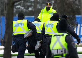 Полиция задерживает человека у моста Амбассадор. С начала протестов в Канаде возбуждено более 60 уголовных дел из-за хулиганства, краж, повреждения имущества и преступлений на почве ненависти. 13 февраля 2022 года.