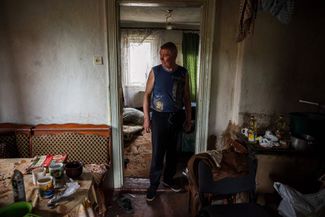 Местный житель осматривает свой дом, в котором квартировали российские военные. 