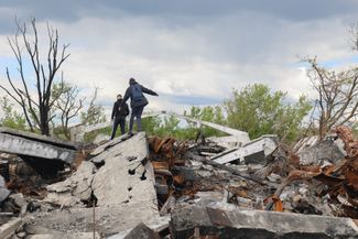Подростки на развалинах здания в селе Малая Рогань Харьковского района. Украинская армия вернула контроль над этим селом в конце марта.