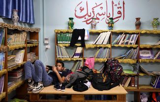 Палестинский юноша, укрывшийся в школе ООН в городе Газа. 13 мая 2021 года