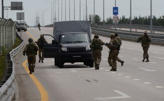 Wagner fighters near vehicles on the highway.