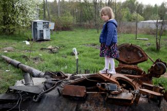 Девочка стоит на уничтоженном российском танке неподалеку от поселка Макаров Киевской области