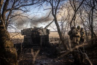 Украинские военные закрывают уши во время работы артиллерийской установки M109, которая обстреливает позиции войск РФ в районе Угледара