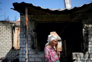 Семидесятишестилетняя жительница Чернигова у своего дома, разрушенного в ходе российского обстрела